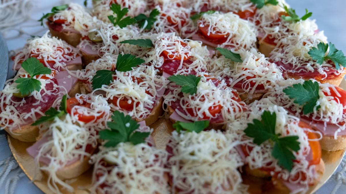 Close-up of tasty bruschetta topped with cheese, tomatoes, and parsley, ideal for food photography.